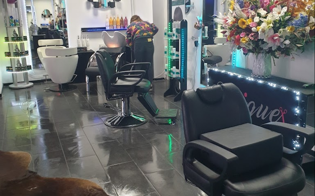 De kappersstoelen in de salon, met bloemen en de balie